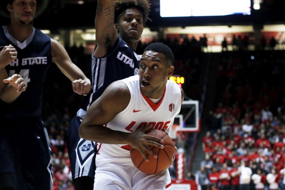 Senior guard Tim Jacobs looks for an open teammate as hes guarded by Utah State players at WisePies Arena Saturday, Jan. 9, 2015. The Lobos recieved their first conference loss to UNLV this past Tuesday and will play Wyoming this Saturday at 2 p.m..