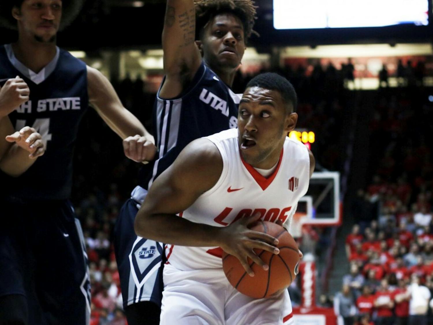 Senior guard Tim Jacobs looks for an open teammate as hes guarded by Utah State players at WisePies Arena Saturday, Jan. 9, 2015. The Lobos recieved their first conference loss to UNLV this past Tuesday and will play Wyoming this Saturday at 2 p.m..