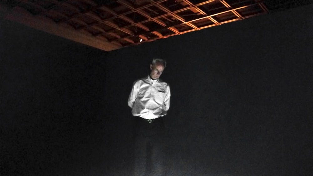 	Oscar Muñoz’s video installation illuminates an attendee at the opening reception of the new summer exhibitions at the UNM Art Museum on Friday. The exhibitions, “Oscar Muñoz: Biografías” and “Luz Restirada: Latin American Photography from the UNM Art Museum,” will run until July 26.