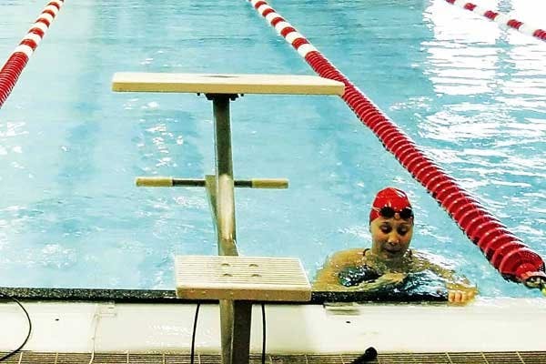 Tori Clarridge catches her breath after a swim meet against CSU at Seidler Natatorium on Saturday. Clarridge juggles swimming and nursing school.