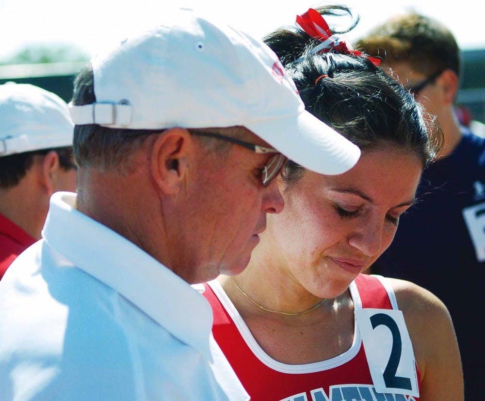Coach Matt Henry talks to distance runner Leslie Luna during the Don Kirby Memorial Invitational track meet at the UNM Track and Field Complex on Saturday. 