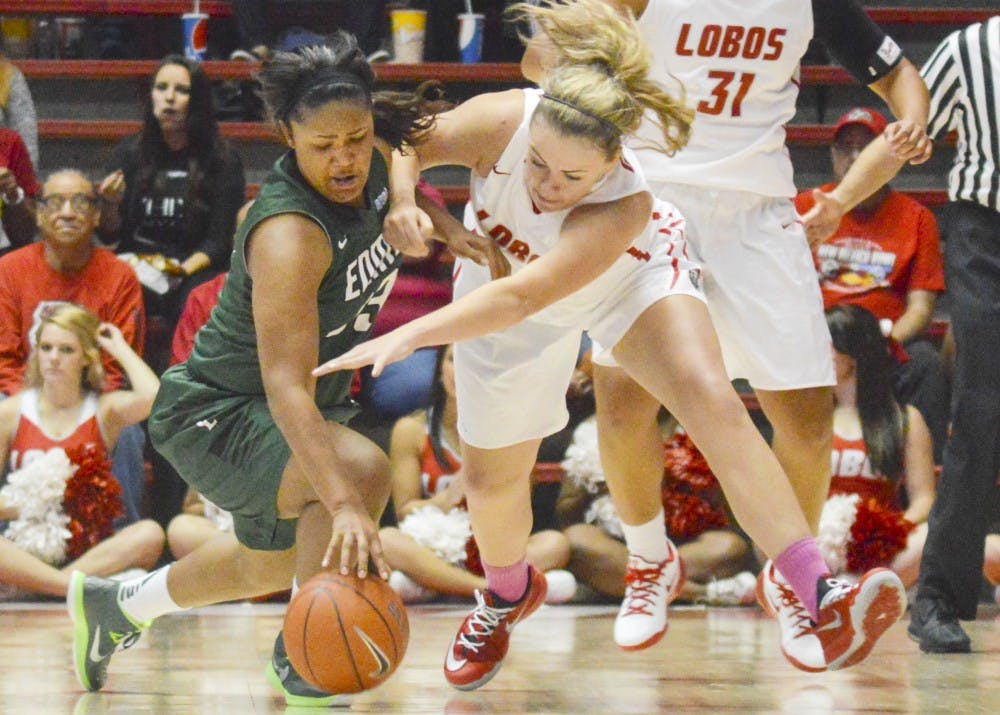 Lobo sophomore forward Josie Greenwood, center, fights for control of the ball with Eastern New Mexico University post Jasmine Johnson, left, during the exhibition game at the Pit on Sunday afternoon. The Lobos won 61-49. 