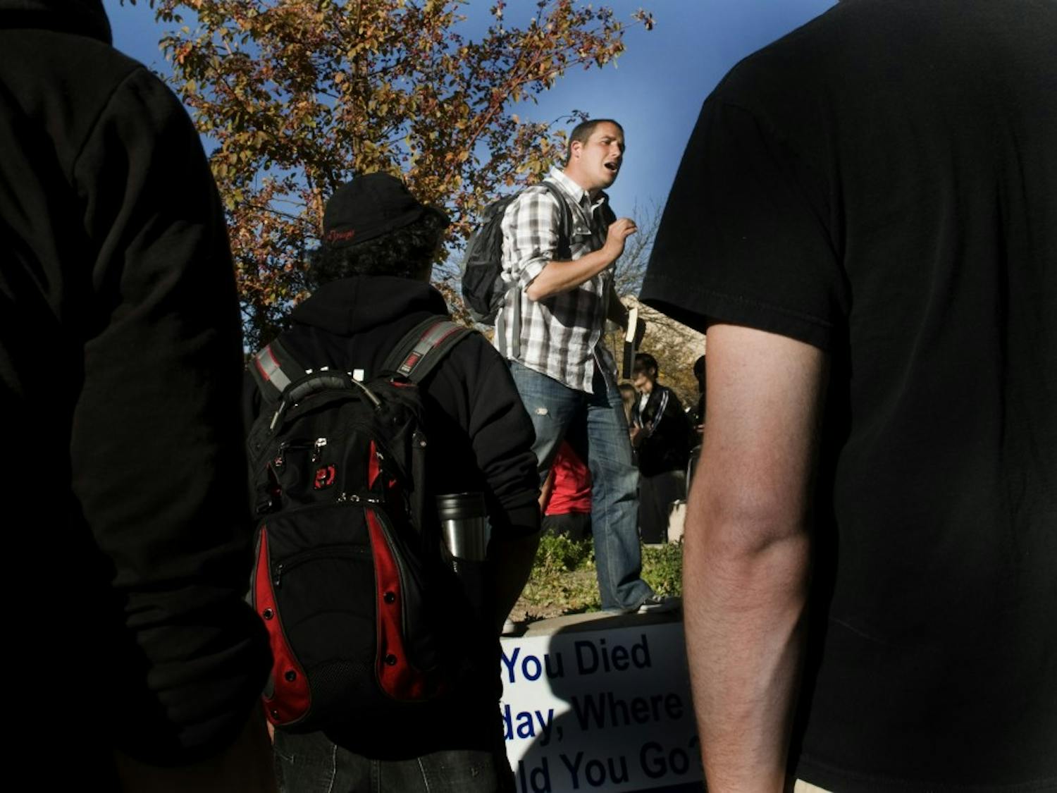 Ken Fleck preaches to a crowd of students outside of the SUB on Monday. Fleck is one of several Christian advocates from across the country who came to talk to UNM students.