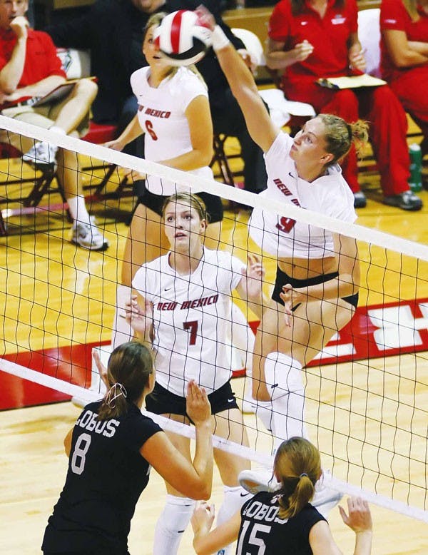 Middle back Allie Suiter spikes the ball over the net during an exhibition match against the Lobo alumni team Saturday in Johnson Center. The Lobos won 3-0. 