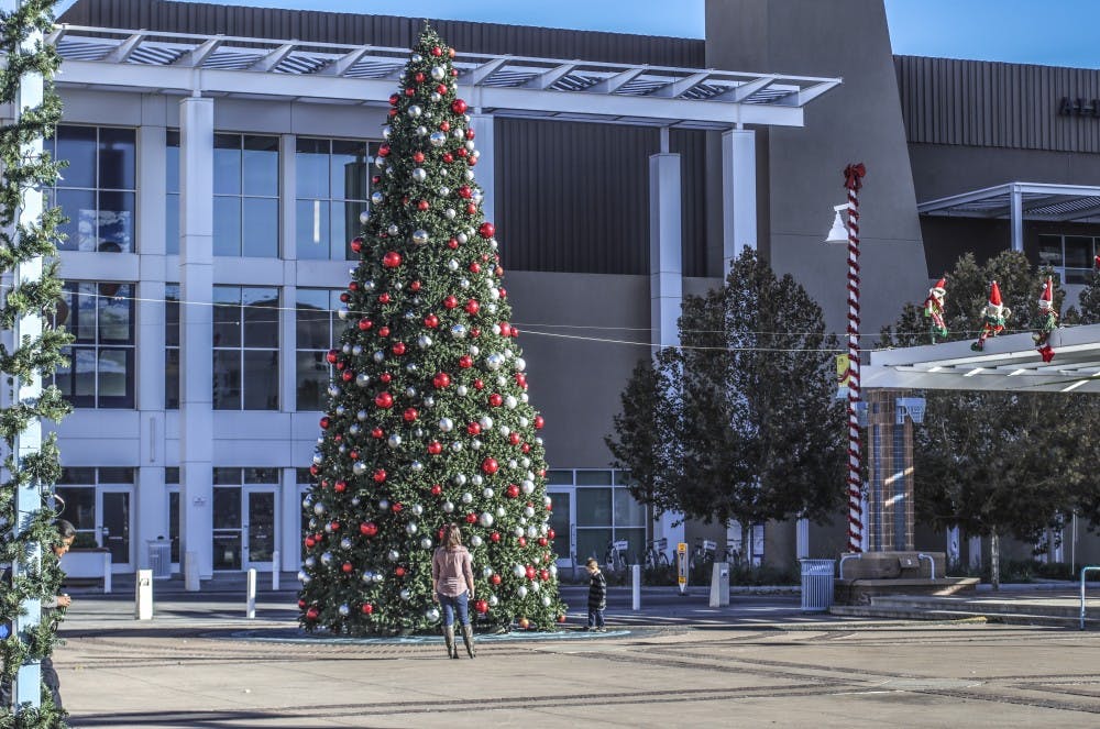 Families wander around the Albuquerque Civic Plaza and look at the Christmas decorations on the afternoon of Nov. 25, 2018.