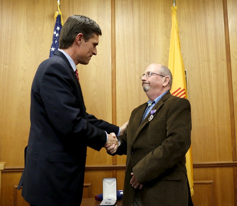 Senator Martin Heinrich shakes hands with&nbsp;Stephen Bailey after presenting him with a purple heart. The ceremony took place in the Roberts in&nbsp;Scholes Hall on Dec. 4, 2015.