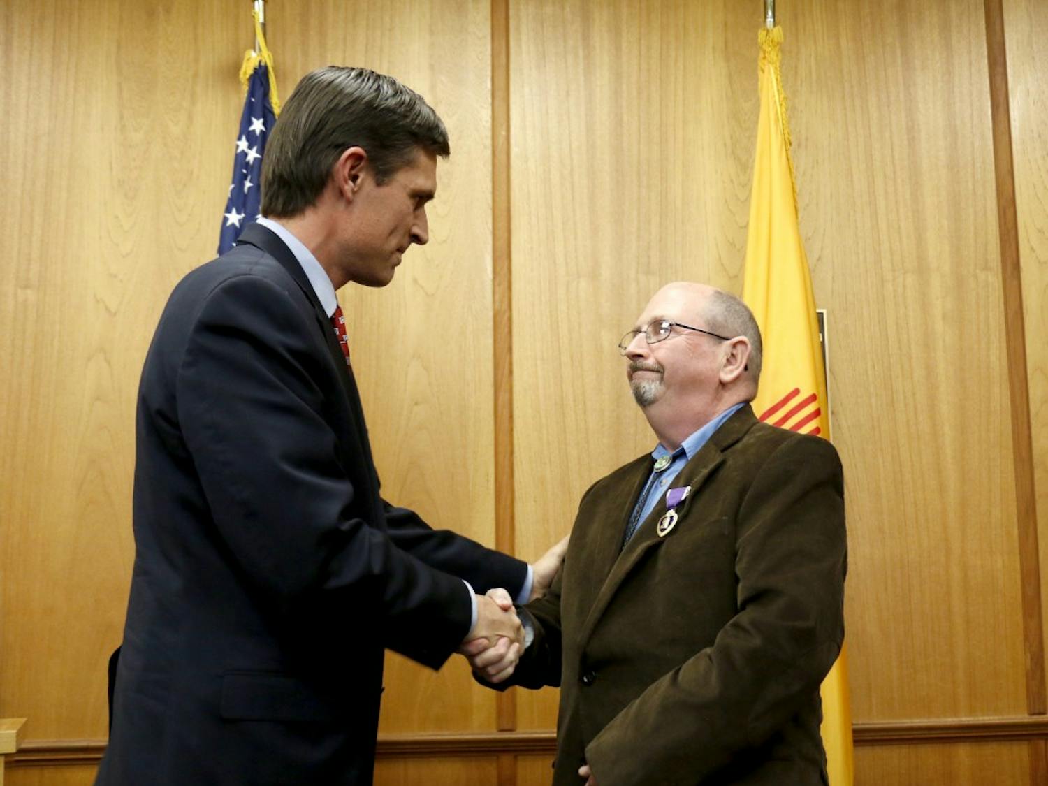 Senator Martin Heinrich shakes hands with&nbsp;Stephen Bailey after presenting him with a purple heart. The ceremony took place in the Roberts in&nbsp;Scholes Hall on Dec. 4, 2015.