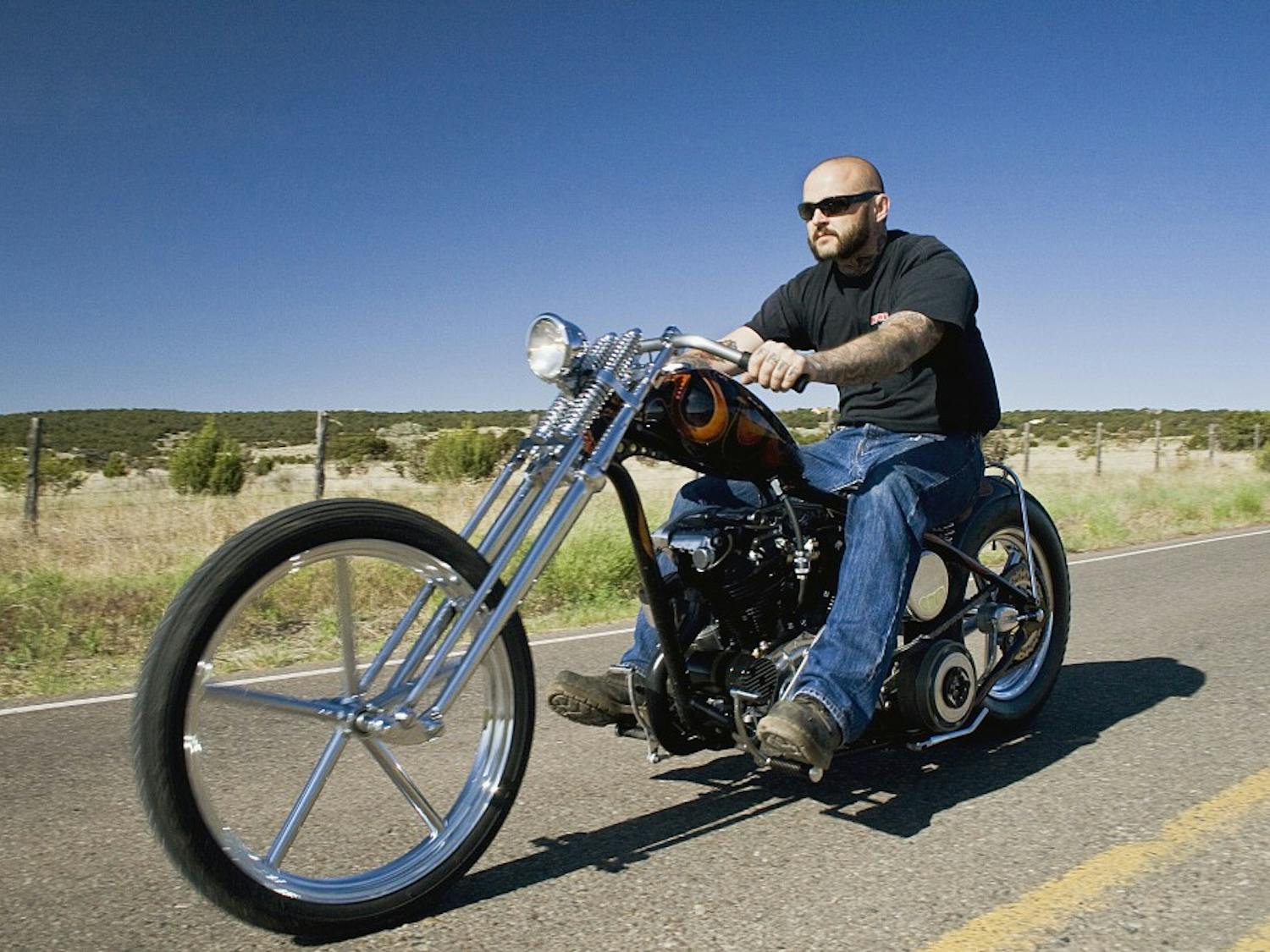 	Trent Schara rides his custom Harley down Highway 317. Schara builds bikes at Atomic Custom, his shop. Check out the Multimedia page at DailyLobo.com to watch ‘Grease,’ the second episode in the ‘Shop talk’ series by Joey Trisolini.