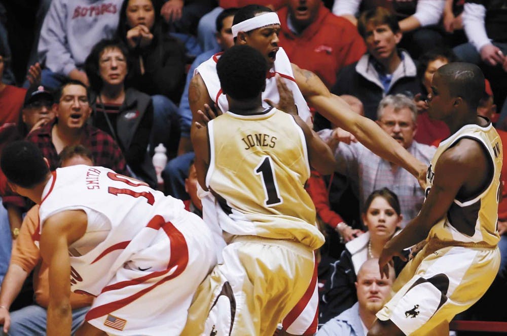 Wyoming guard Brad Jones pushes UNM player J.R. Giddens after Brandon Ewing fouled Giddens in the second half of Tuesday's game at The Pit. A fight broke out, and Ewing and Jones were ejected from the game along with Lobo Jamaal Smith. The Lobos won 91-83