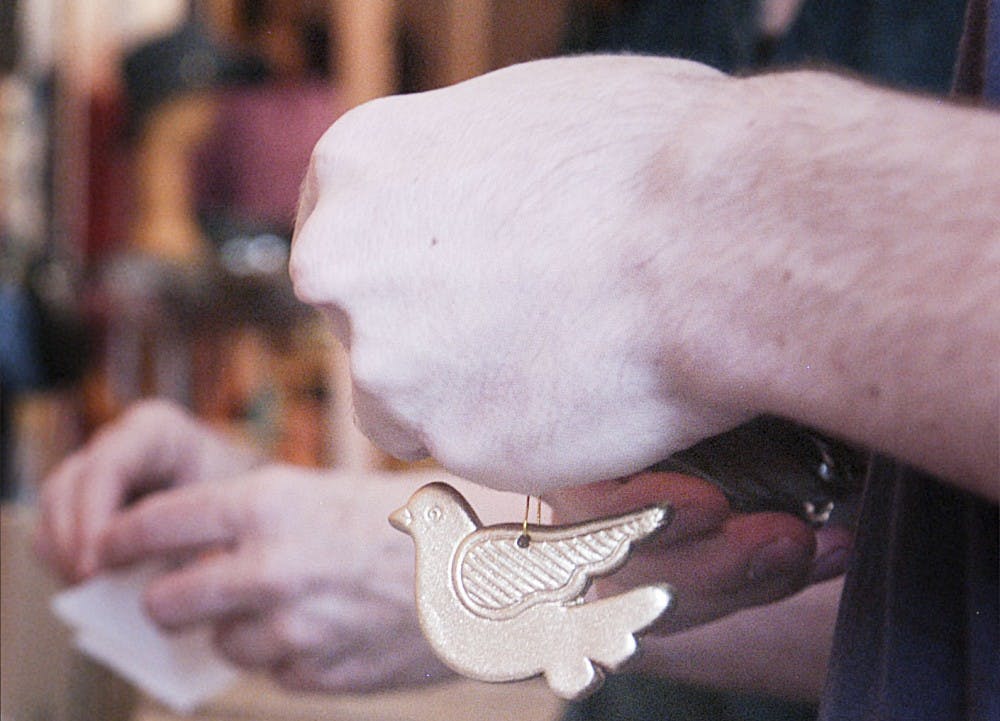 	Volunteers at Peacecraft pull ornaments from packages to sell. 