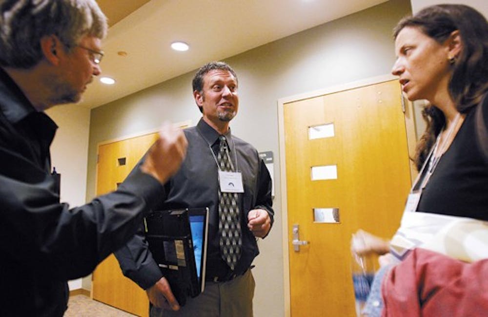 Edward Prather, center, talks with Mark Ondrias and Pam Castaldi outside the SUB Fiesta room before attending a discussion on technology in the classroom Thursday.