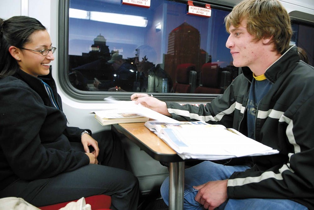 Crystal Mendez and Matthew Totter study while waiting for the Rail Runner to leave the Downtown train station Thursday. 