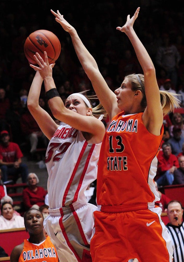 	Forward Amanda Best shoots a basket while Oklahoma State’s Heather Howard blocks the ball during Wednesday’s game at The Pit. The Lobos lost 70-56. 