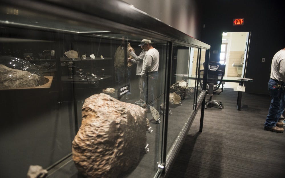 Lee Ann Lloyd shows attendees different types of meteorites at the Meteorite Museum in Northrop Hall Wednesday afternoon. The museum added spot lights and glass cases to show meteorites from around the world.
