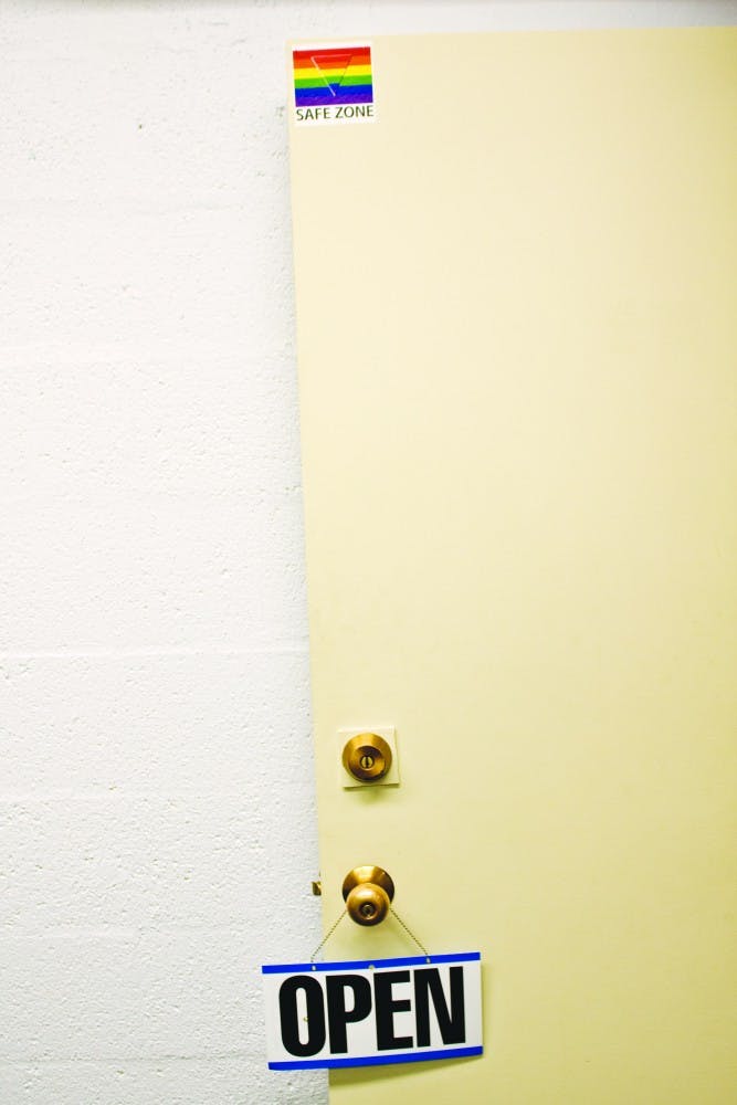 	Representatives of the LGBTQ Resource Center set an “Open” sign on the door
to the building near Dane Smith Hall. The on-campus center, which opened
Aug. 27, welcomes students of any sexual orientation to seek support.