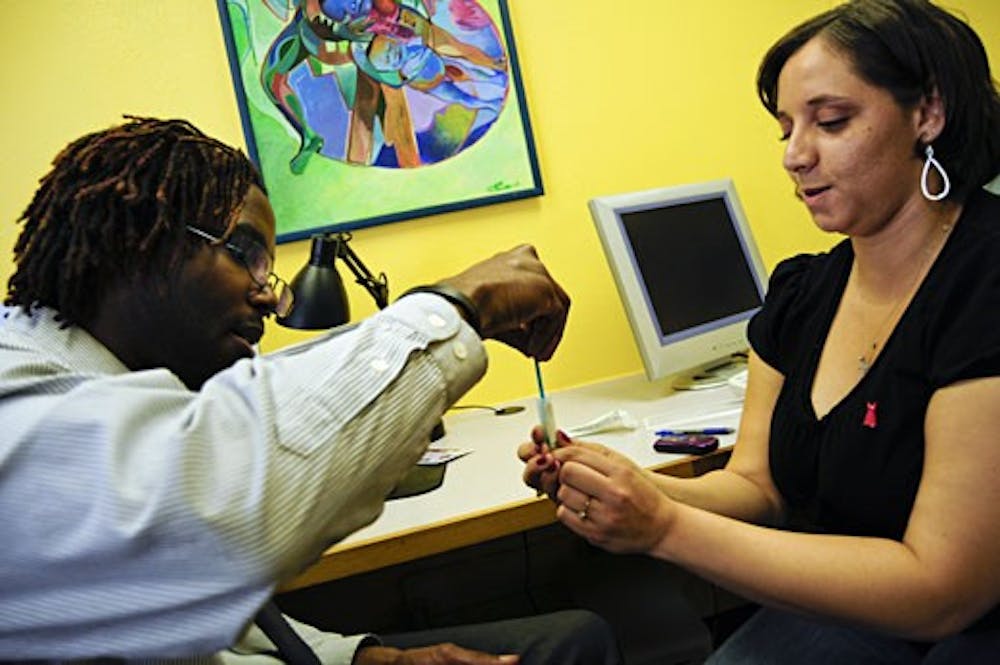 Leann Morgan tests Hakim Bellamy for HIV on Friday at Mesa Vista Hall. Bellamy helped promote Black HIV/AIDS Awareness Day on campus, which included free testing.