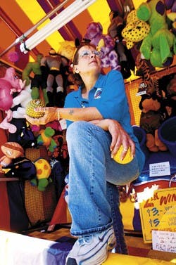 Carnival worker Joy Johnson runs a game booth called "Tubs," at the New Mexico State Fair on Saturday. She will travel to seven states by December. 