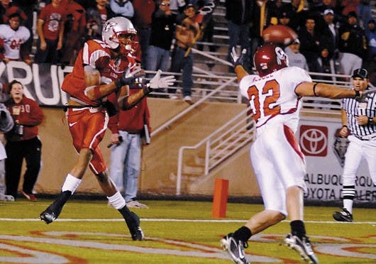 Lobo wide receiver Travis Brown catches the Lobos' go-ahead touchdown against Utah defensive back Eric Weddle during UNM's 34-31 win at University Stadium on Thursday.