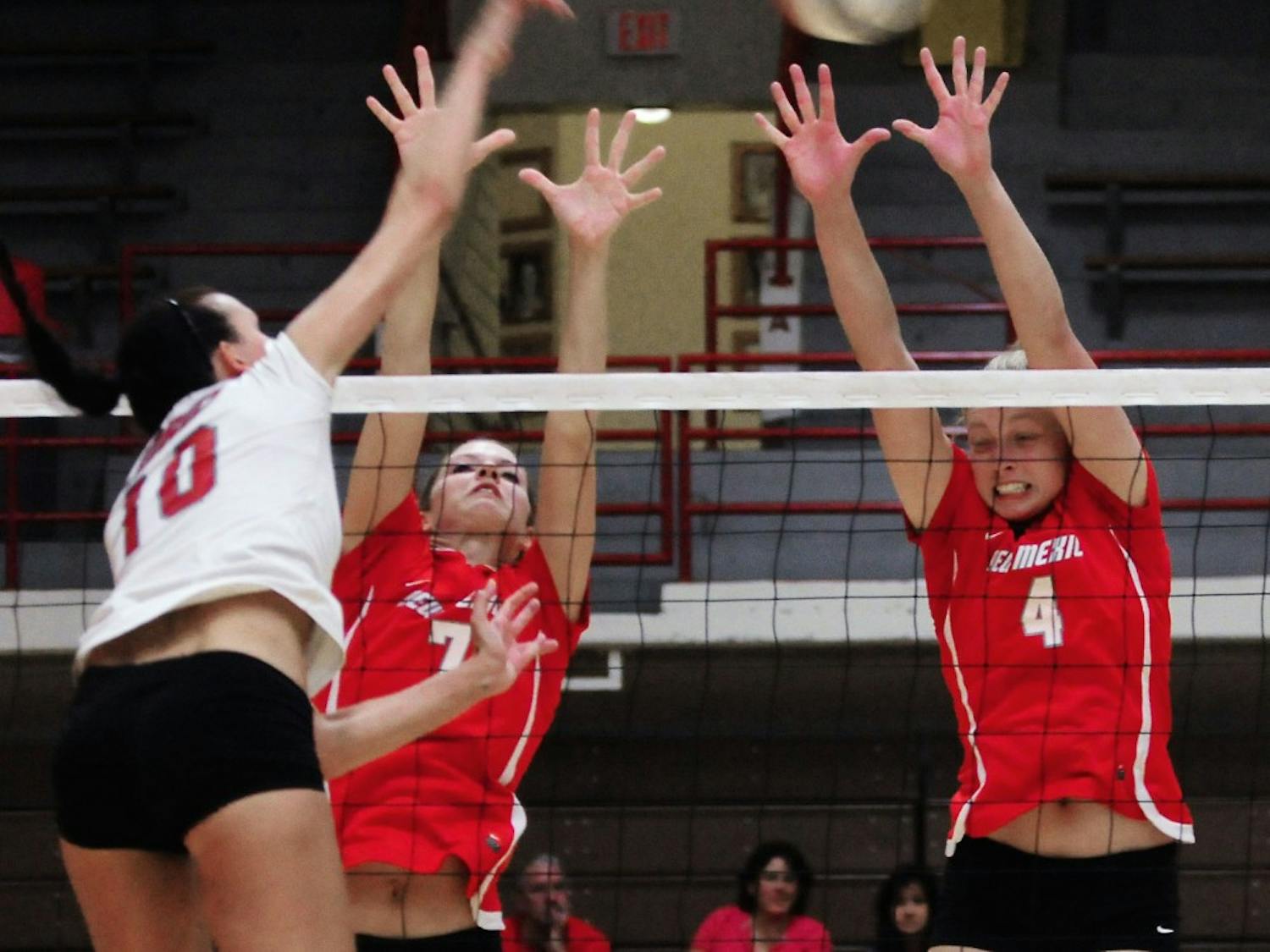 Ashley Rhoades, right, and Jade Michaelsen defend the net during UNM’s annual cherry-silver scrimmage at Johnson Gym on Saturday.