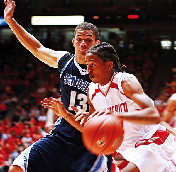 UNM's Darren Prentice drives toward the basket past San Diego's Danny Brown during Saturday's 57-47 win at The Pit.