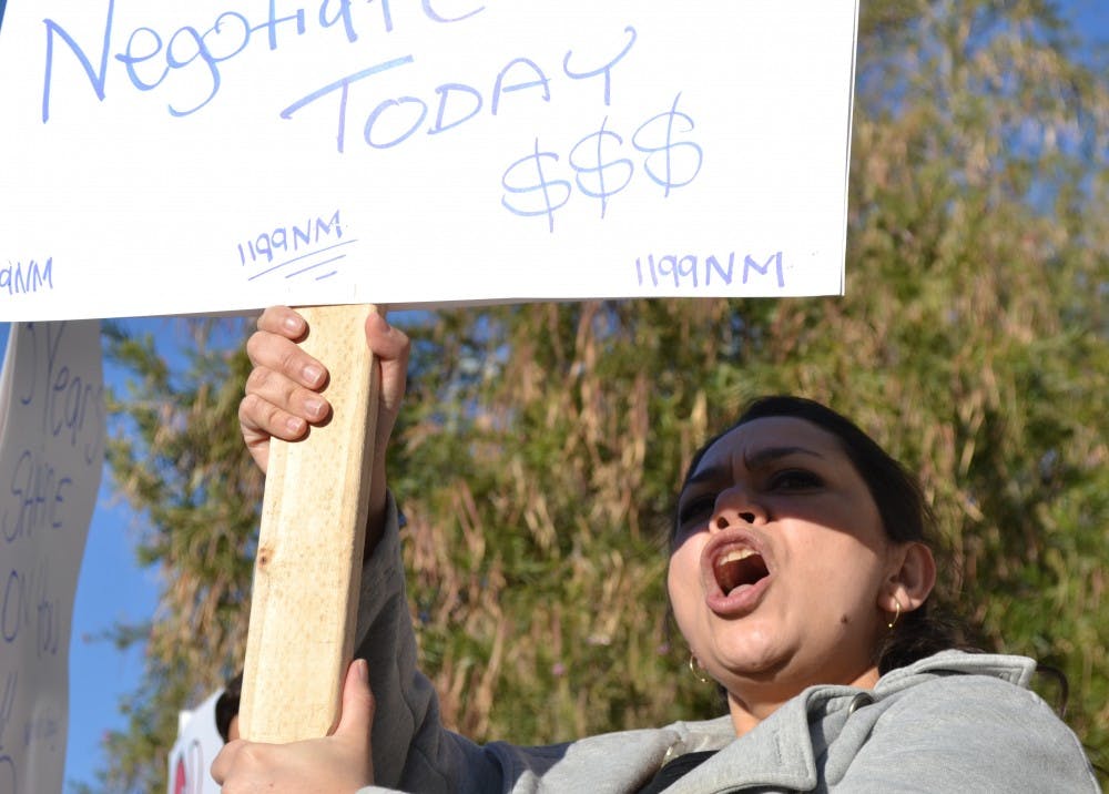 	Linda Weahkee, a registered nurse at UNM Hospital, attracts motorists’ attention with a placard along Lomas Boulevard in front of UNMH early Tuesday morning. Hospital employees rallied at the site to protest the hospital administration’s alleged neglect toward workers’ annual wage increases and union authority. Weahkee, who works night shifts, said she went straight to the protest immediately after her shift. “I’ll sleep when I get home,” she said. “I’m a union baby.”