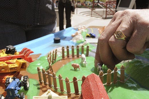 Vernon Hershberger moves a model cow in a display at the Sustainability Expo at Cornell Mall on Wednesday. Hershberger, who attended the expo in honor of Earth Day, explained the dangers of livestock waste contaminating water supplies.