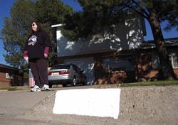 Student Elizabeth Le Cam stands in front of her home near Wyoming Boulevard and Candelaria Road on Monday. Le Cam alleges she gave $10 to a man who said he was fundraising for emergency response services by repainting addresses on curbs, but he never fini