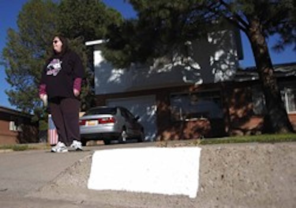 Student Elizabeth Le Cam stands in front of her home near Wyoming Boulevard and Candelaria Road on Monday. Le Cam alleges she gave $10 to a man who said he was fundraising for emergency response services by repainting addresses on curbs, but he never fini