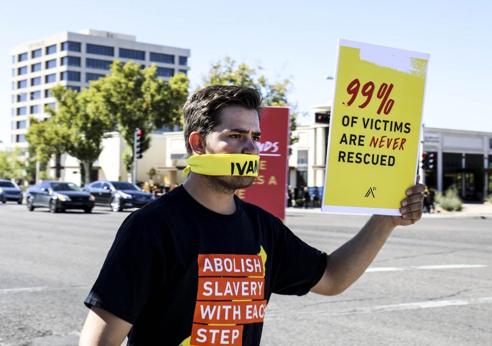 An A21 participant holds up a sign to raise awareness of modern day slavery on Oct. 14, 2017 near Uptown. Participants gathered at Lewis University before walking down to Louisiana Blvd. 