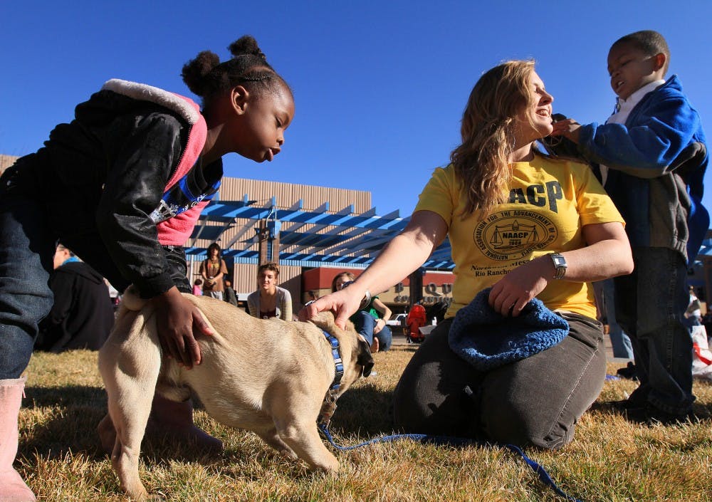 	Ahmathyah Nickols, left, and her brother Solomon play with Amanda Powers and her dog, Handsome Jack, at a ceremony at Civic Plaza on Sunday. The ceremony was part of a parade in honor of Dr. Martin Luther King Jr.
