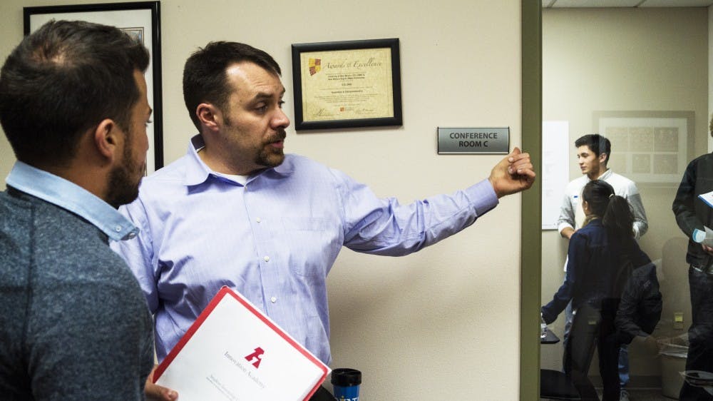 Robert Del Campo, an executive director for the Innovation Academy guides a student in an Internship Fair which was held in Science and Technology Park Building on Tuesday evening. This fair was Innovation Academy's first attempt to involve six companies to guide students with their application documents.