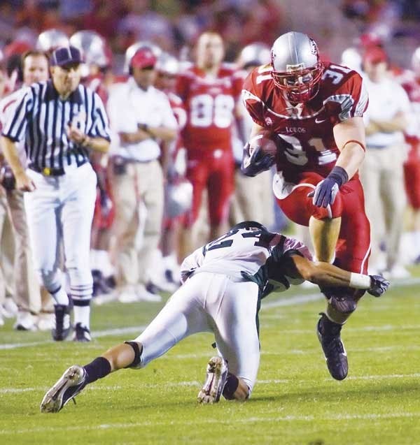 UNM's Matt Quillen jumps over Sacramento State's Jerome Jenkins in the third quarter Saturday at University Stadium. The Lobos won 58-0. 