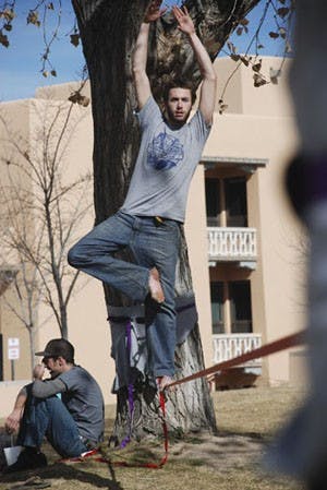 David Bray executes a yoga position on a slackline in front of Johnson Center on Thursday. 