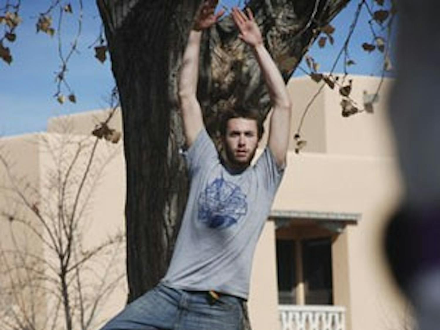 David Bray executes a yoga position on a slackline in front of Johnson Center on Thursday.