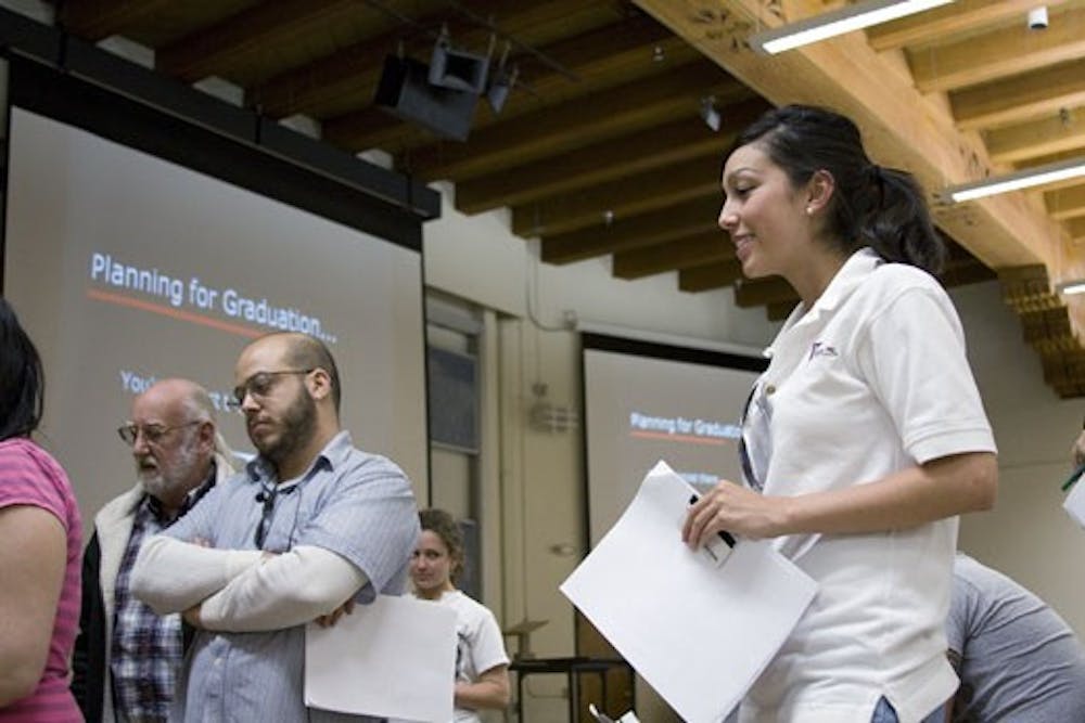 Rachael Gonzales, right, and Eric Lander wait to register for graduation Monday in the Anthropology Building.