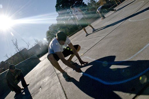 Student Evan Holden, center, Brian Moore, left, and other students use chalk to write a campaign slogan in Smith Plaza on Sunday. Moore is running for ASUNM president on the Lobos Unidos slate. Holden is helping the slate campaign. Early voting for the Ap