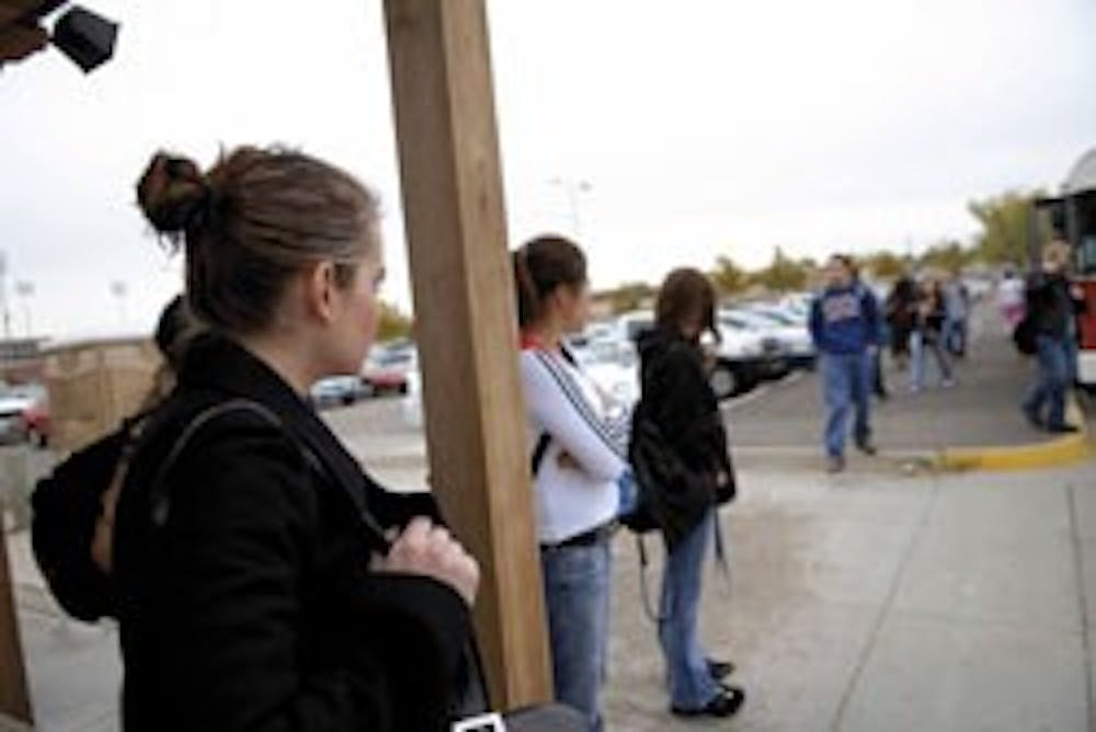 Student Samantha Aragon, left, waits for the South Lot shuttle Tuesday. 