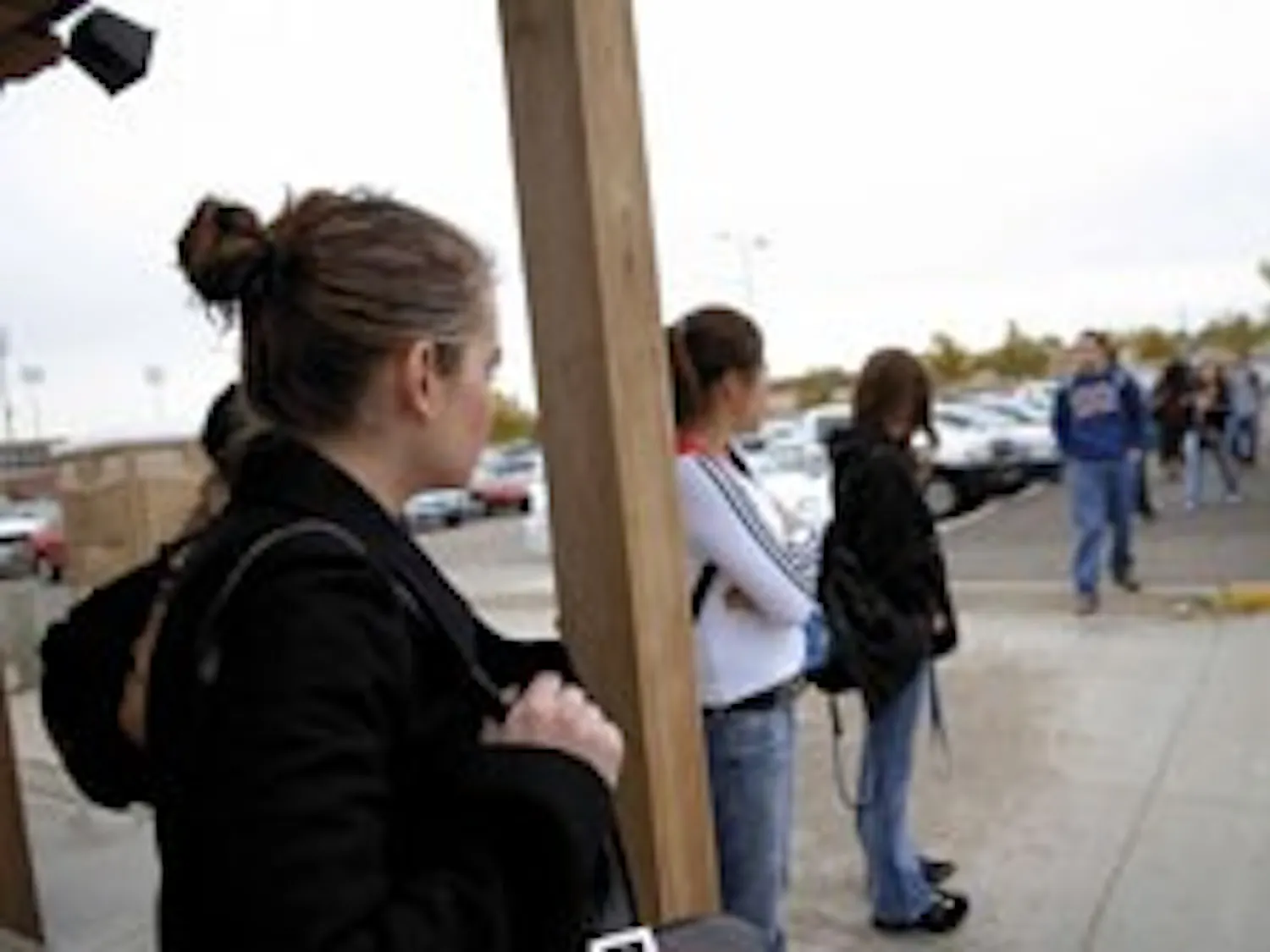 Student Samantha Aragon, left, waits for the South Lot shuttle Tuesday.