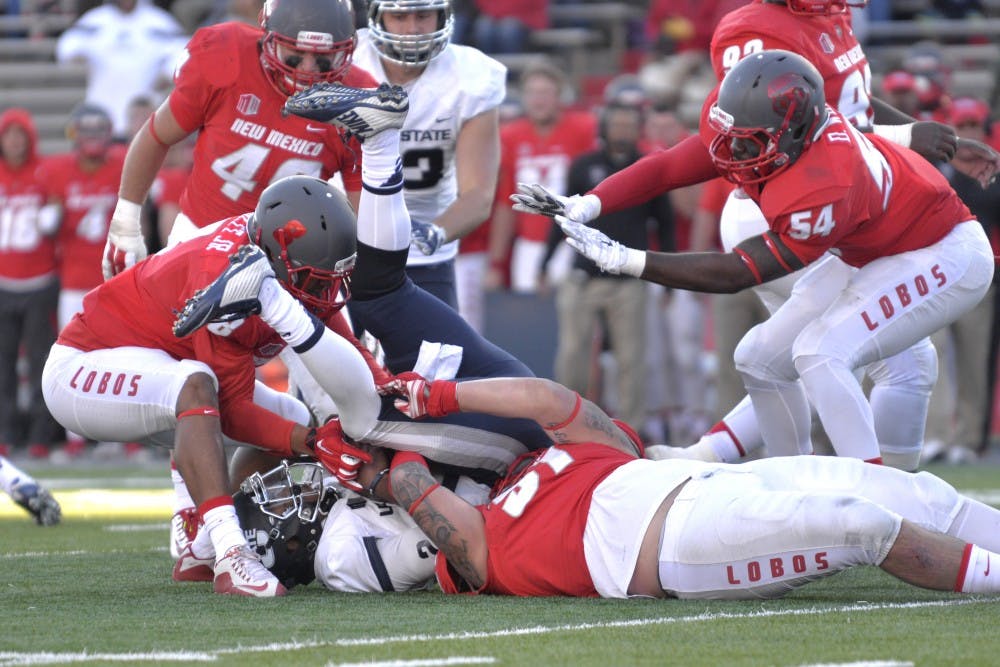 The Lobos defense brings down a Utah State player during their game at University Stadium Nov. 7. UNM plays Boise State this Saturday and is one win away from bowl eligibility with three games remaining in the 2015 season.&nbsp;