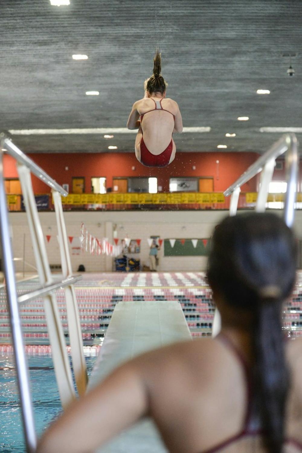 Madeline Horner dives through the air as Allyson Concepcion watches at the Seidler Natatorium on Saturday, Oct. 24. The Lobos lost to Wyoming 170-130.
