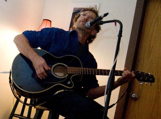 Joe Galloway looks up to audience applause after playing a song at open-mic night.