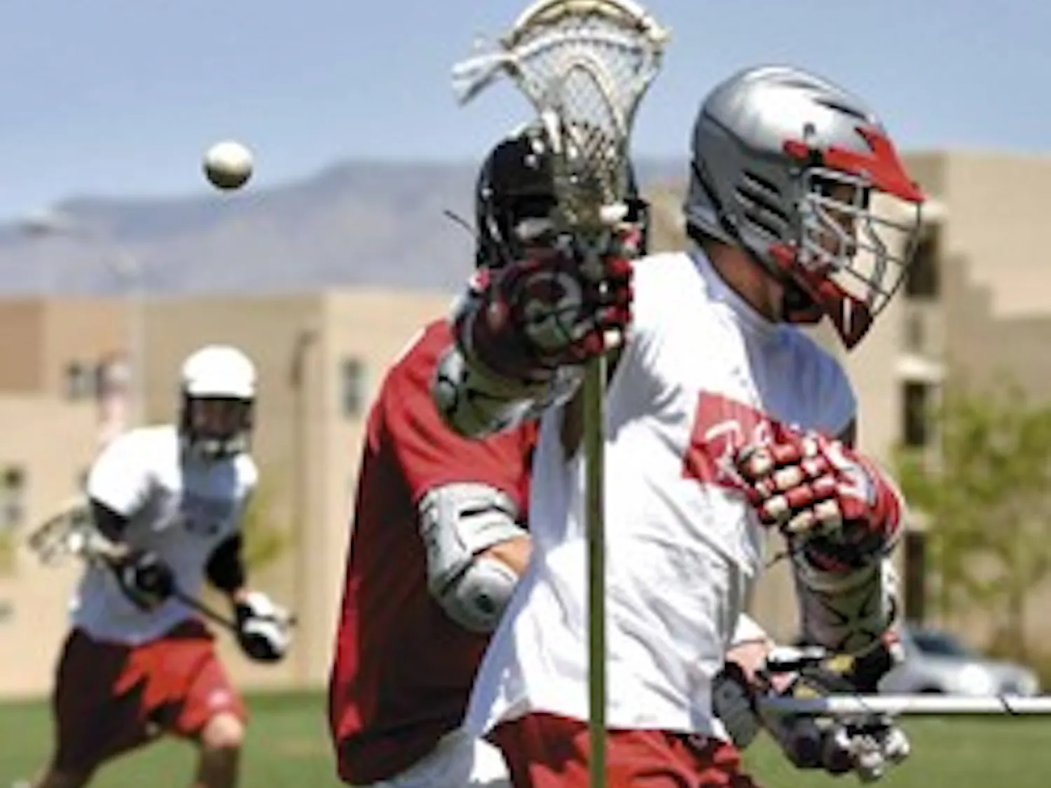 UNM lacrosse player Mike Mooney, right, fights with Wes Stallcup for the ball during a practice at Johnson Field on April 23.