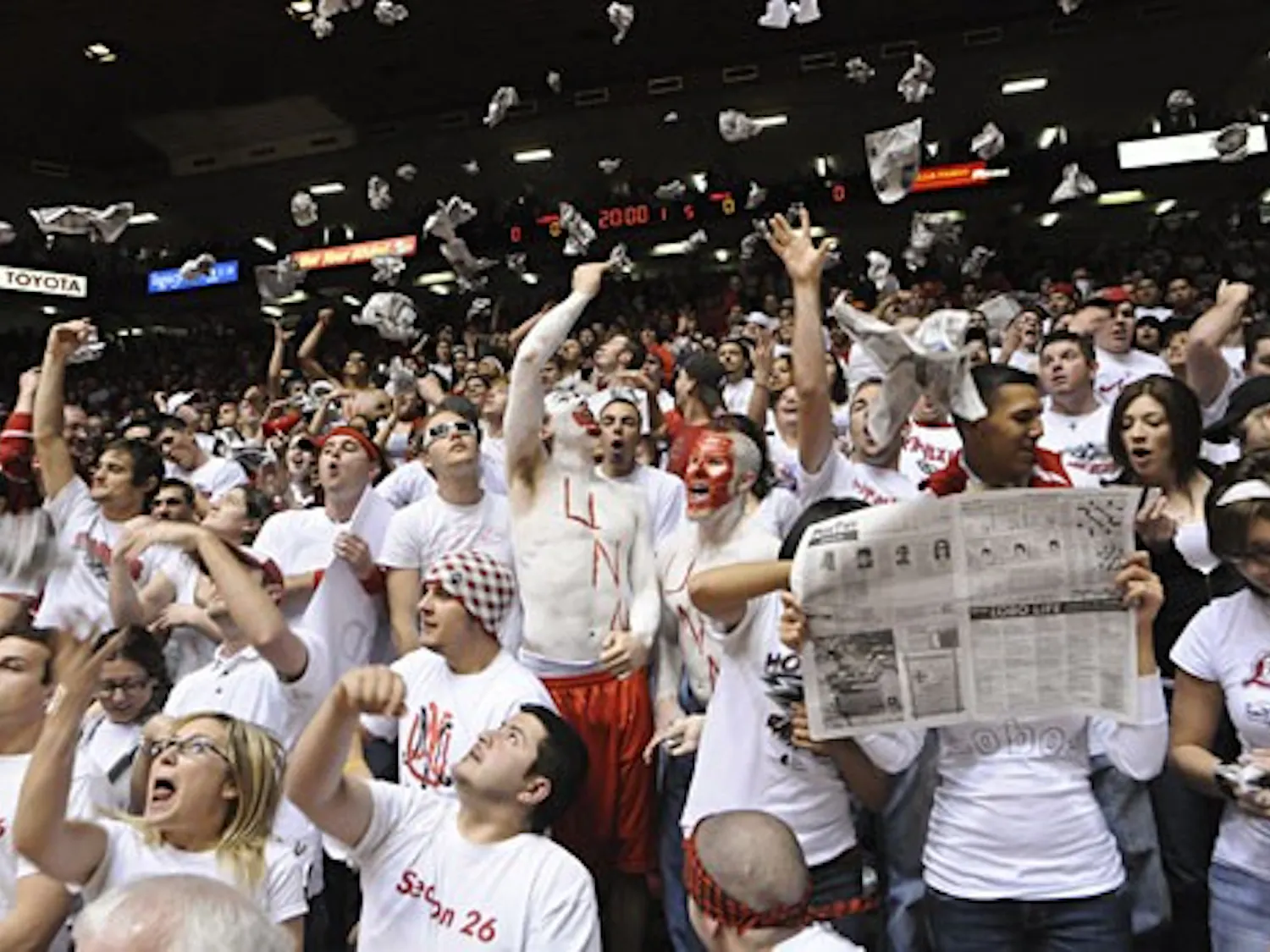 Students in Section 26 of The Pit shred and toss newspapers in the air during pre-game introductions Saturday. UNM beat UNLV 73-69.