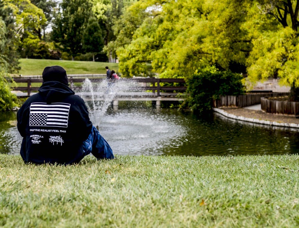 A visitor at the UNM duck pond wears a hoodie depicting an upside down American flag on Sept. 27, 2017. The flag should only be displayed or flown with the union down ?as a signal of dire distress in instances of extreme danger to life or property,? according to the United States Flag Code. 


