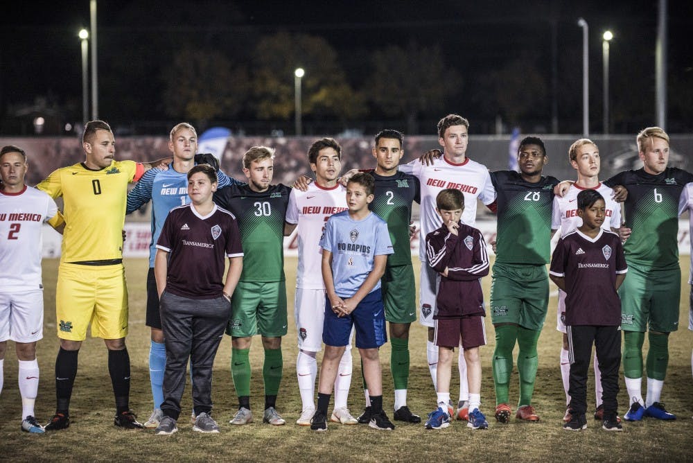 Members of the UNM and Marshall Men's soccer teams line up together before the game in a show of solidarity on Saturday night at the UNM Soccer Complex. The game ended in a 2-2 draw.