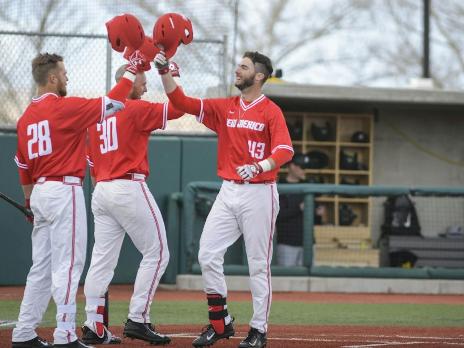 A group of Lobo players come together at home plate to celebrate scoring against Bringhamton Sunday, Feb. 19, 2017 at Santa Ana Star Field. 