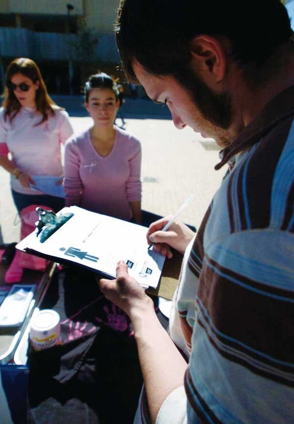 Student Mark Sarracino fills out a letter of support Tuesday at Smith Plaza that will be given to a breast cancer survivor. The Colleges Against Cancer has activities planned through Friday. 