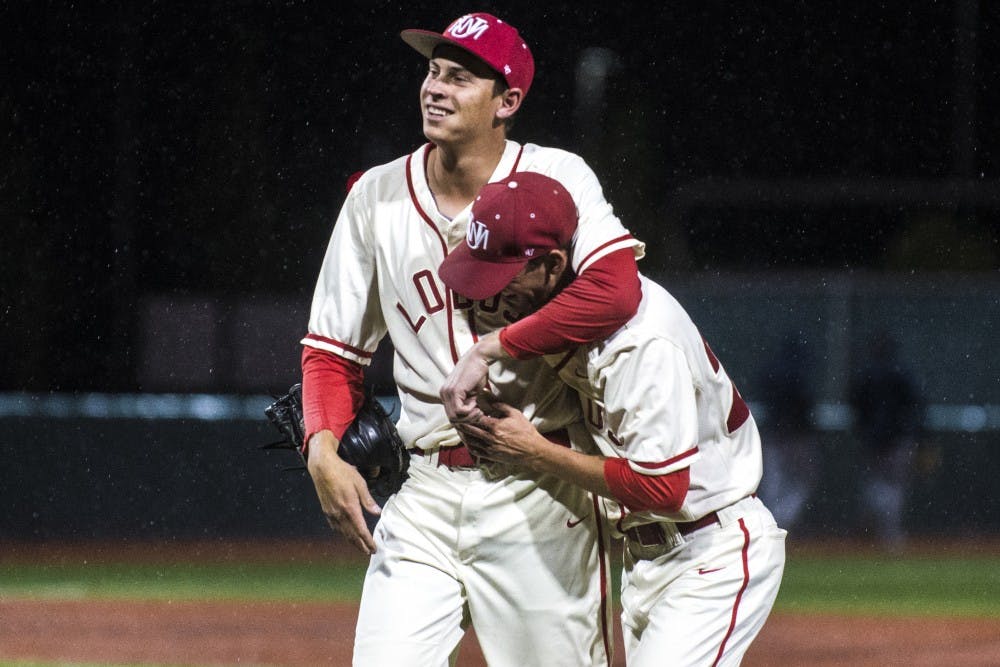 Lobos junior pitcher Carson Schneider embraces senior pitcher Alex Estrella as rain falls at Santa Ana Star Field Friday night. UNM has taken the first two games of the series and will go for the sweep against Fresno State Sunday.&nbsp;