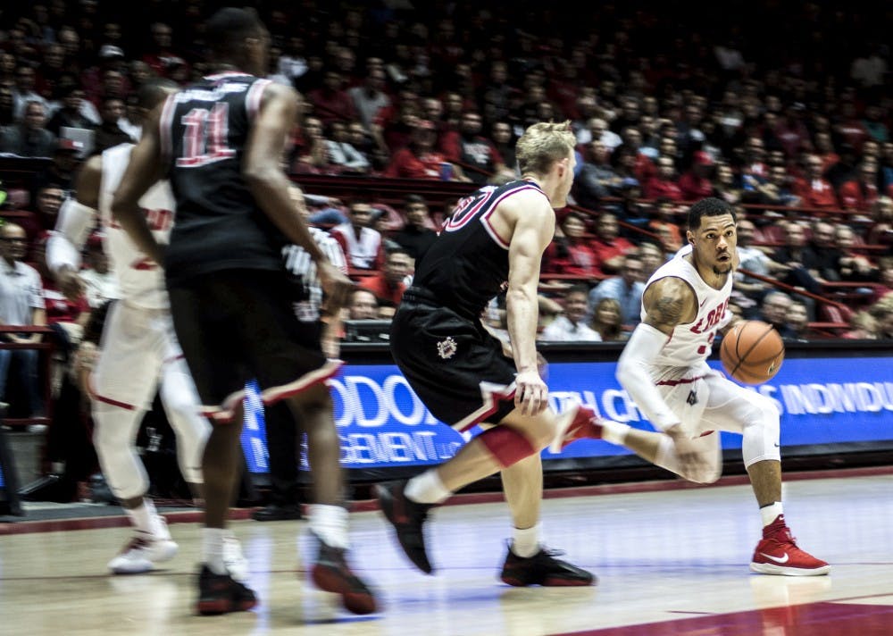 Troy Simons drives past Fresno State's Sam Bittner during Saturday's game at Dreamstyle Arena, aka&nbsp;The Pit. The Lobos won 95-86 in overtime.