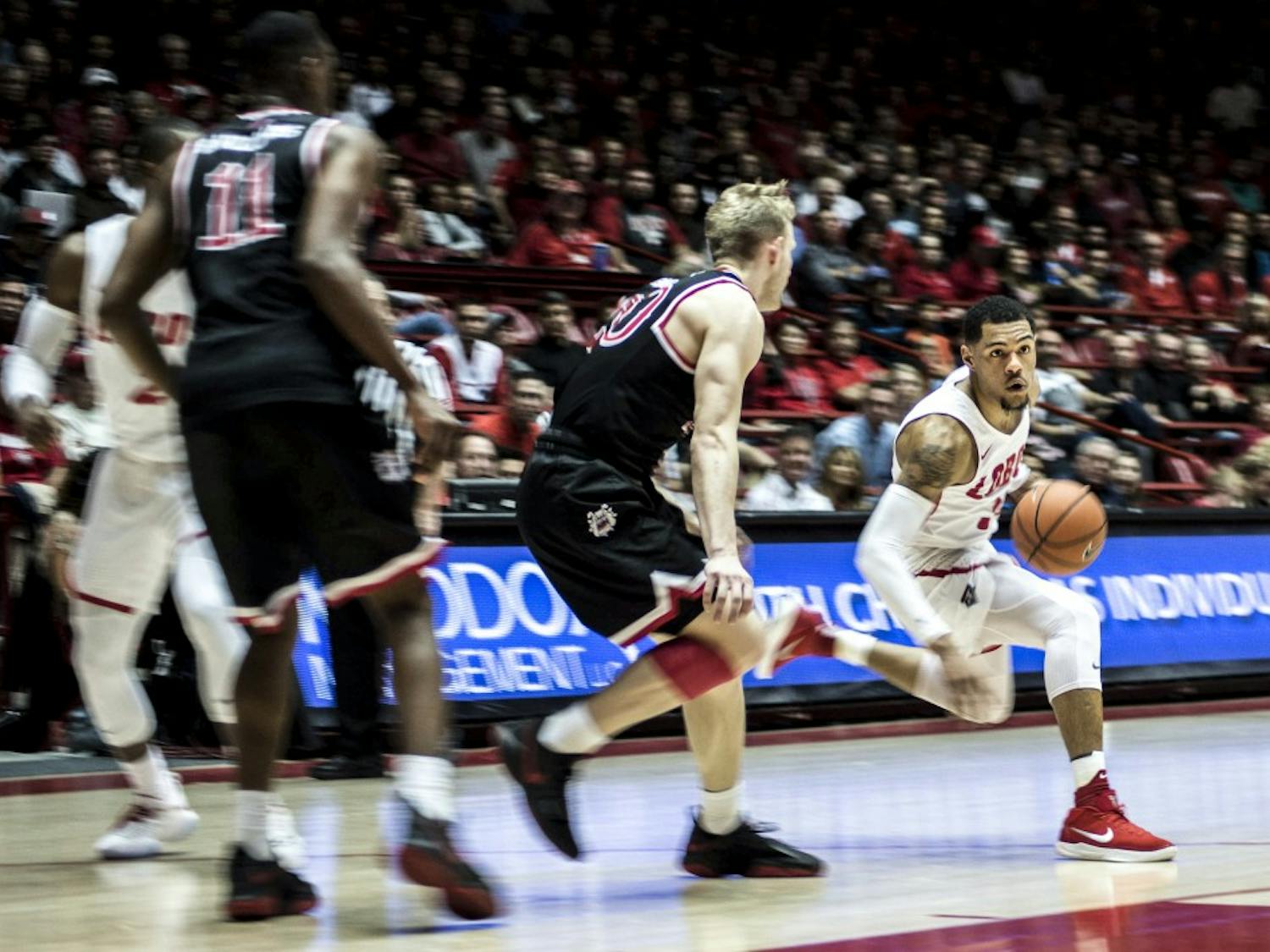 Troy Simons drives past Fresno State's Sam Bittner during Saturday's game at Dreamstyle Arena, aka&nbsp;The Pit. The Lobos won 95-86 in overtime.